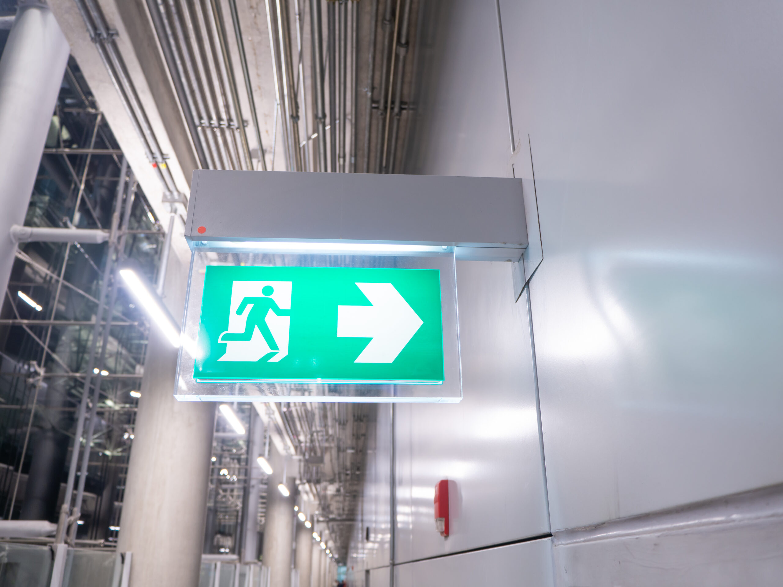 led sign in corridor point way out of resident apartment building, Fire warning exit with arrow symbol sign box light Emergency Exit